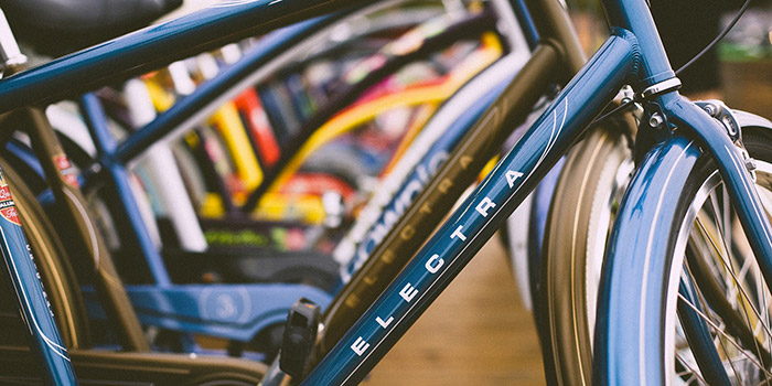 Portrait d'un vélo électrique Electra mis en valeur dans un magasin animé, symbolisant la modernité et la praticité avec un design attractif et des couleurs vives. Idéal pour un transport urbain durable et respectueux de l'environnement.