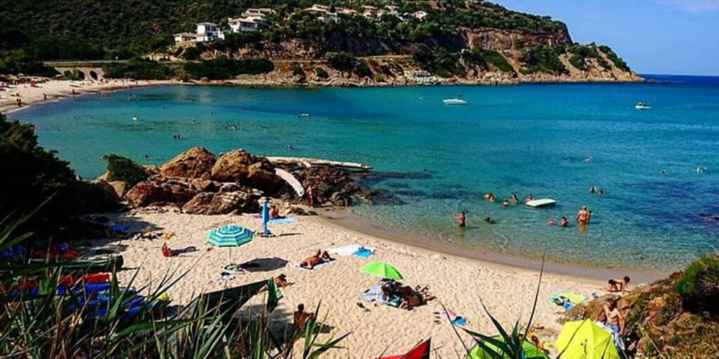 Cette image capture une journée parfaite à la plage, où une famille profite du soleil, des parasols colorés et des eaux cristallines d'une mer bleue. Atmosphère conviviale et chaleureuse.