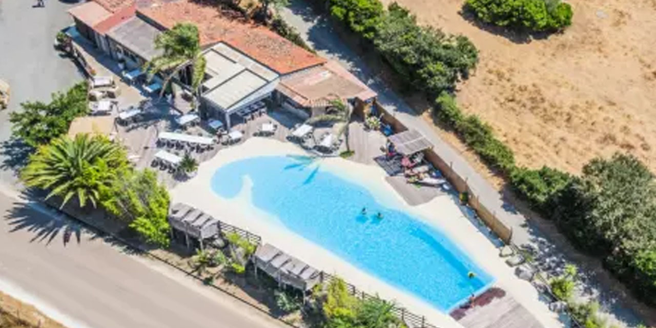 Cette vue aérienne de la piscine d'hôtel évoque des moments de plaisir et de convivialité avec des couleurs vives et un environnement chaleureux, parfaits pour la détente estivale.