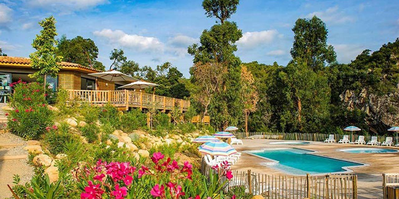 Image d'un camping de rêve en montagne, avec une piscine, des fleurs colorées et des équipements de détente, idéale pour le séjour.