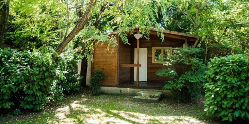 Maison en bois nichée dans un écrin de verdure, offrant sérénité et évasion, idéale pour se ressourcer loin du stress.