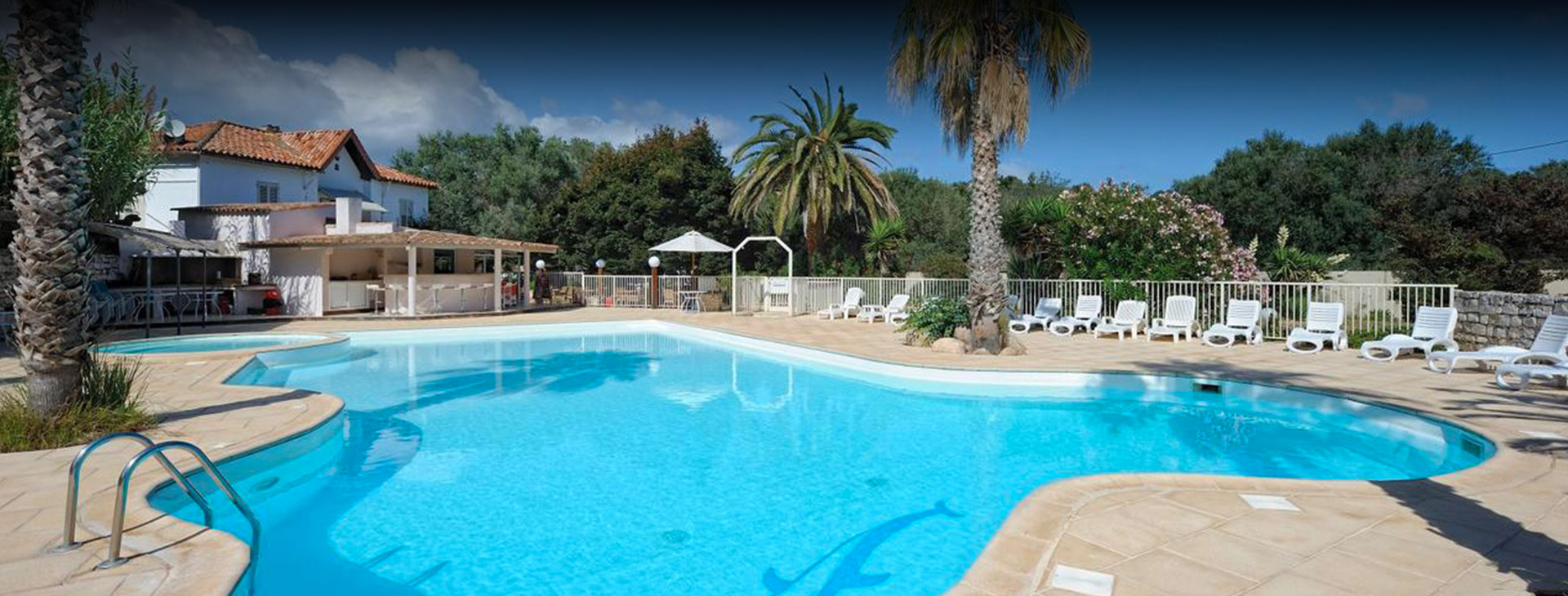 Atmosphère de vacances au bord de la piscine ensoleillée L'image capture la beauté relaxante d'une piscine ensoleillée, entourée d'une nature luxuriante, offrant un lieu parfait pour des vacances en famille ou entre amis. Un appel à la détente et à l'évasion.