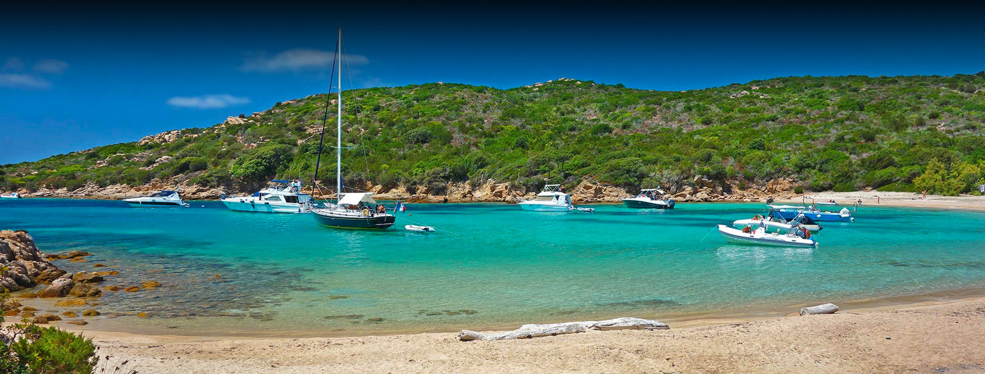 Plage paisible avec bateaux flottants au soleil Plage tranquille avec bateaux flottant doucement sur une eau cristalline entourée de verdure, évoquant détente et sérénité.