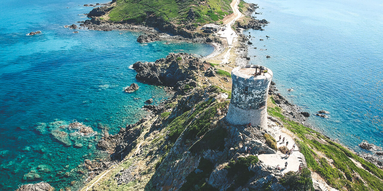 Tour historique surplombant la mer Méditerranée depuis une falaise, entourée de nature et de paysages à couper le souffle.