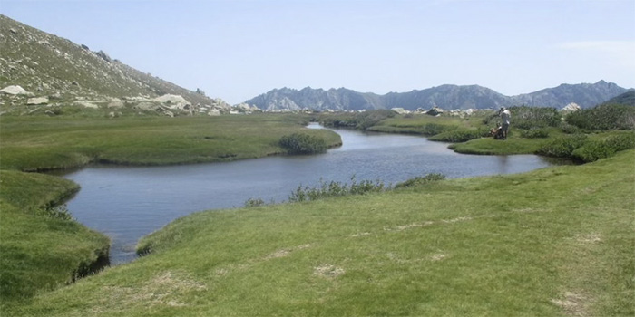 Paysage enchanteur de lac de montagne entouré de verdure, parfait pour une journée sereine en plein air et l'évasion en nature.